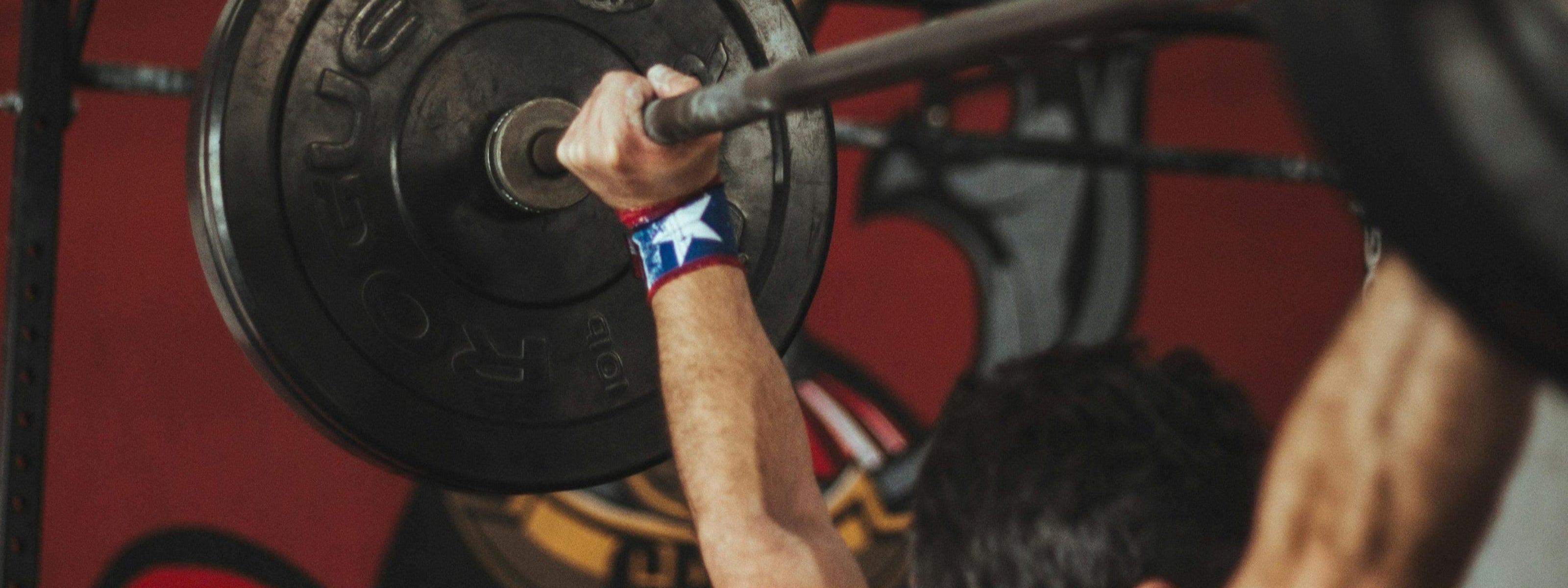Person lifting a barbell with a blurred background